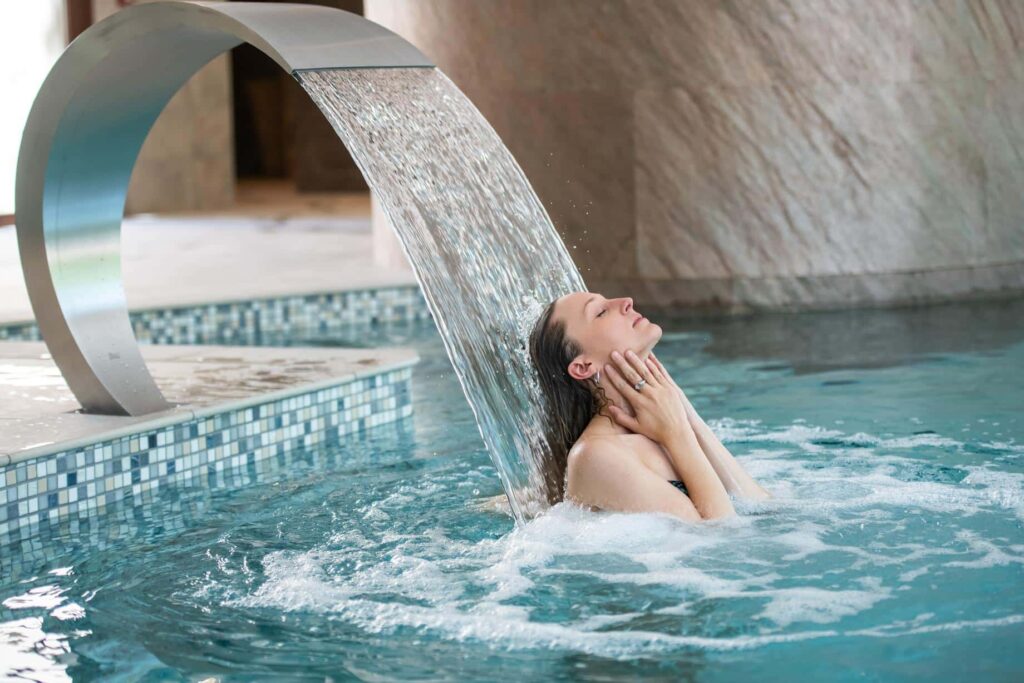 A moment of relaxation under the water jet of the Bio Spa's indoor pool.
