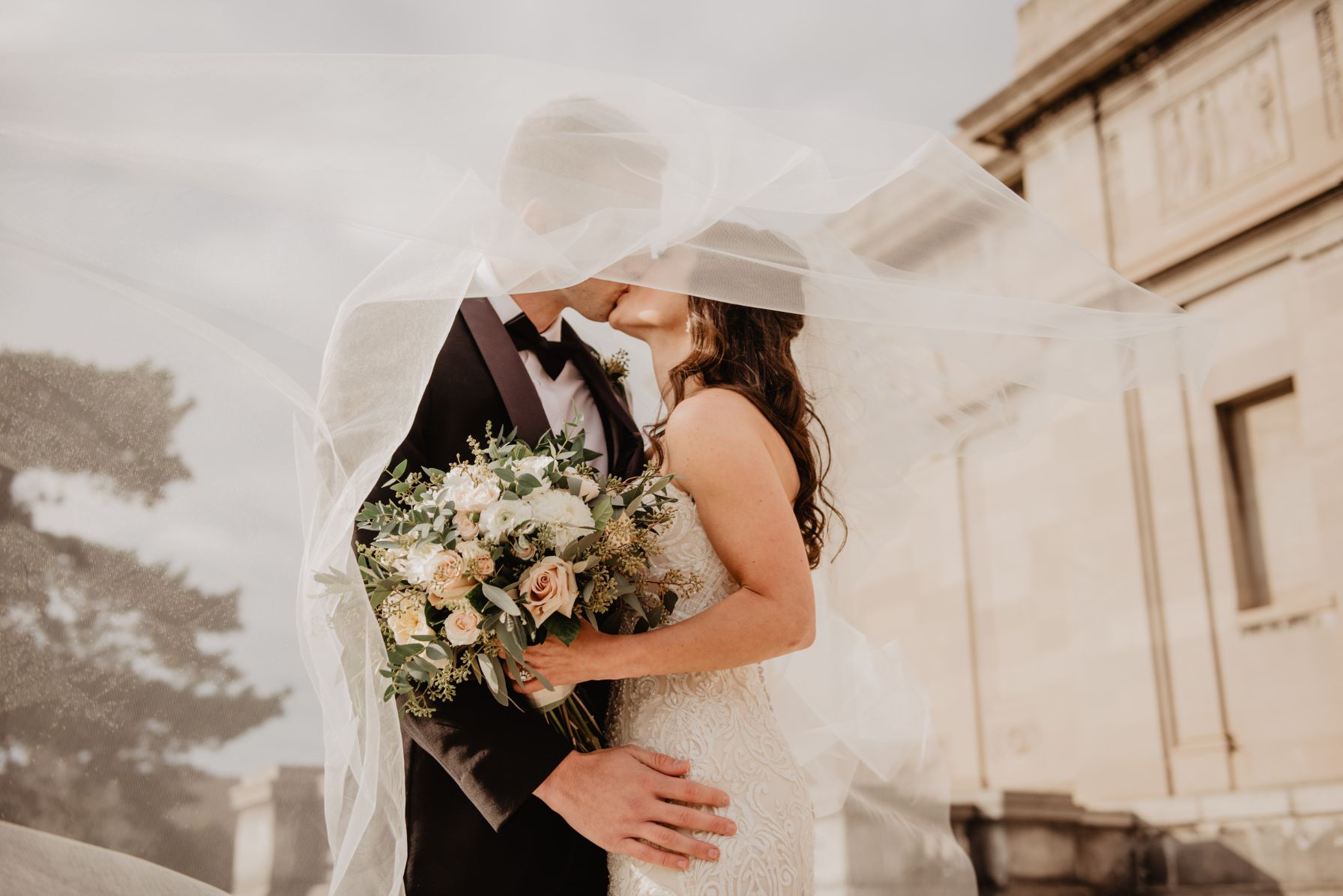 Mariés avec bouquet de fleurs devant le Château de Massillan